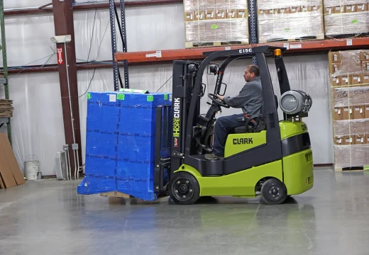 New Clark C15C forklift carrying a wrapped pallet past pallet racking in a Delaware warehouse